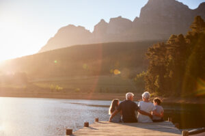 Grandparents sitting on a jetty with their grandchildren.