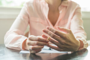 A woman removing her wedding ring.