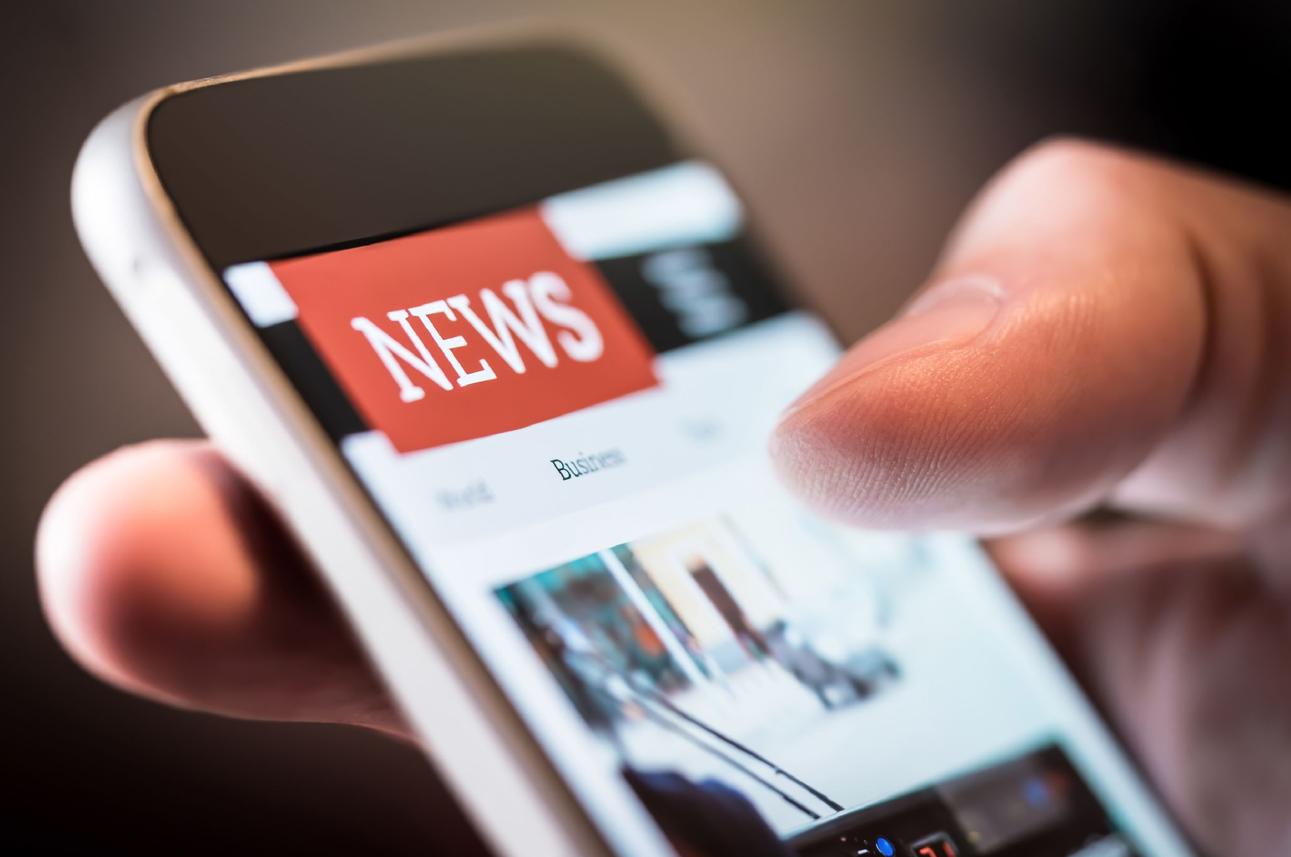 A person using a smartphone to read the news.