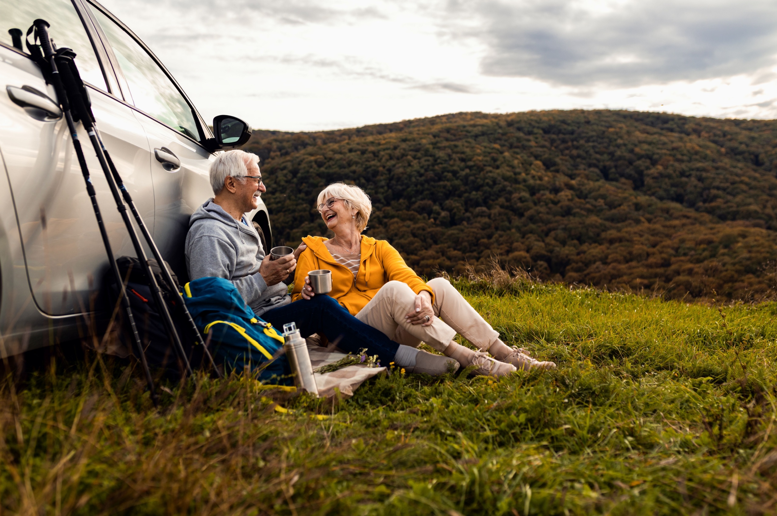 An older couple resting after a hike.