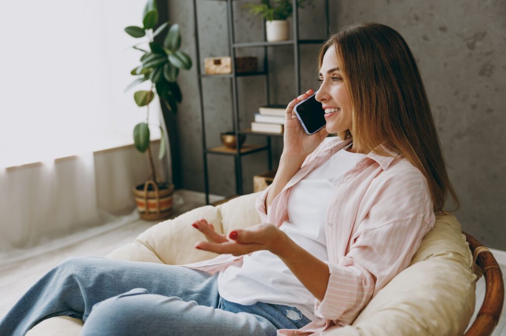 A woman talking on the phone at home.