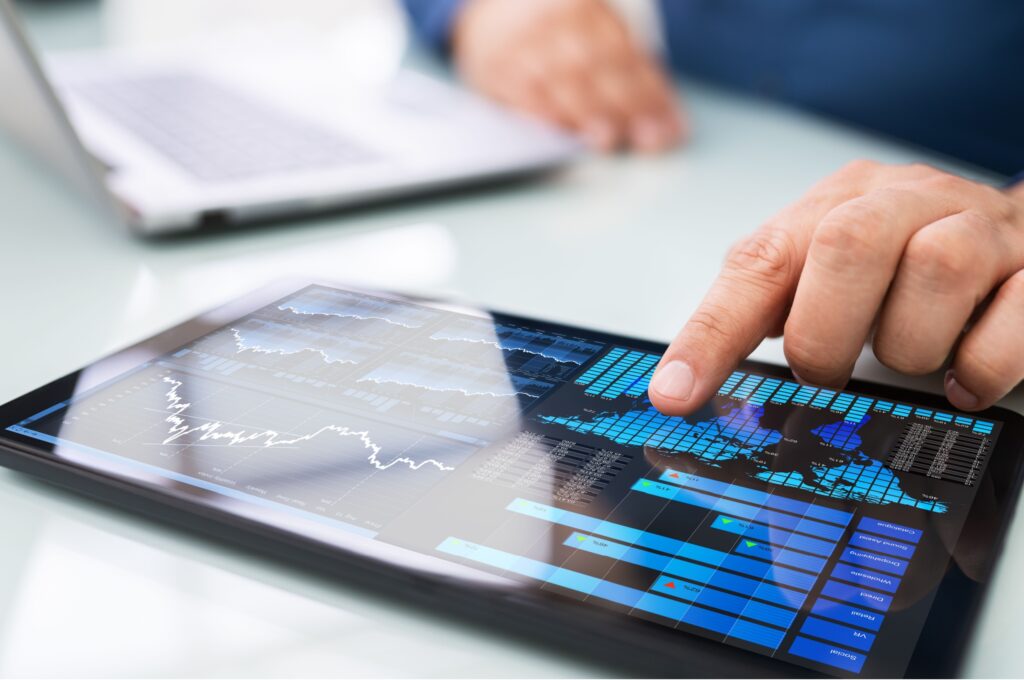 A man looking at graphs on a tablet.