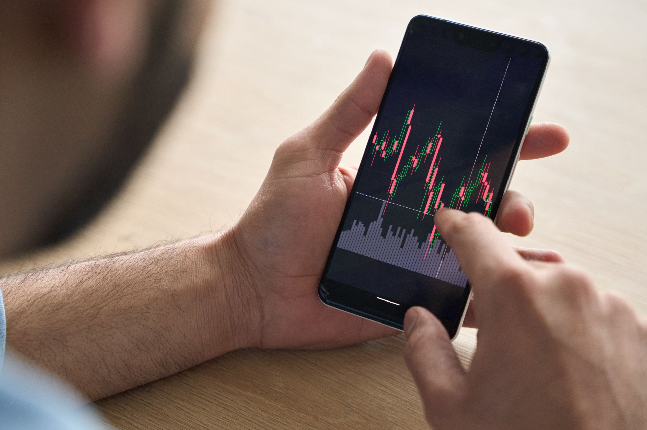A man looking at investment performance on his phone.