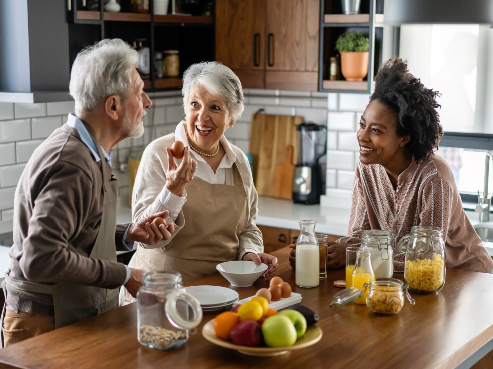 Parents talking to their adult child in their kitchen.