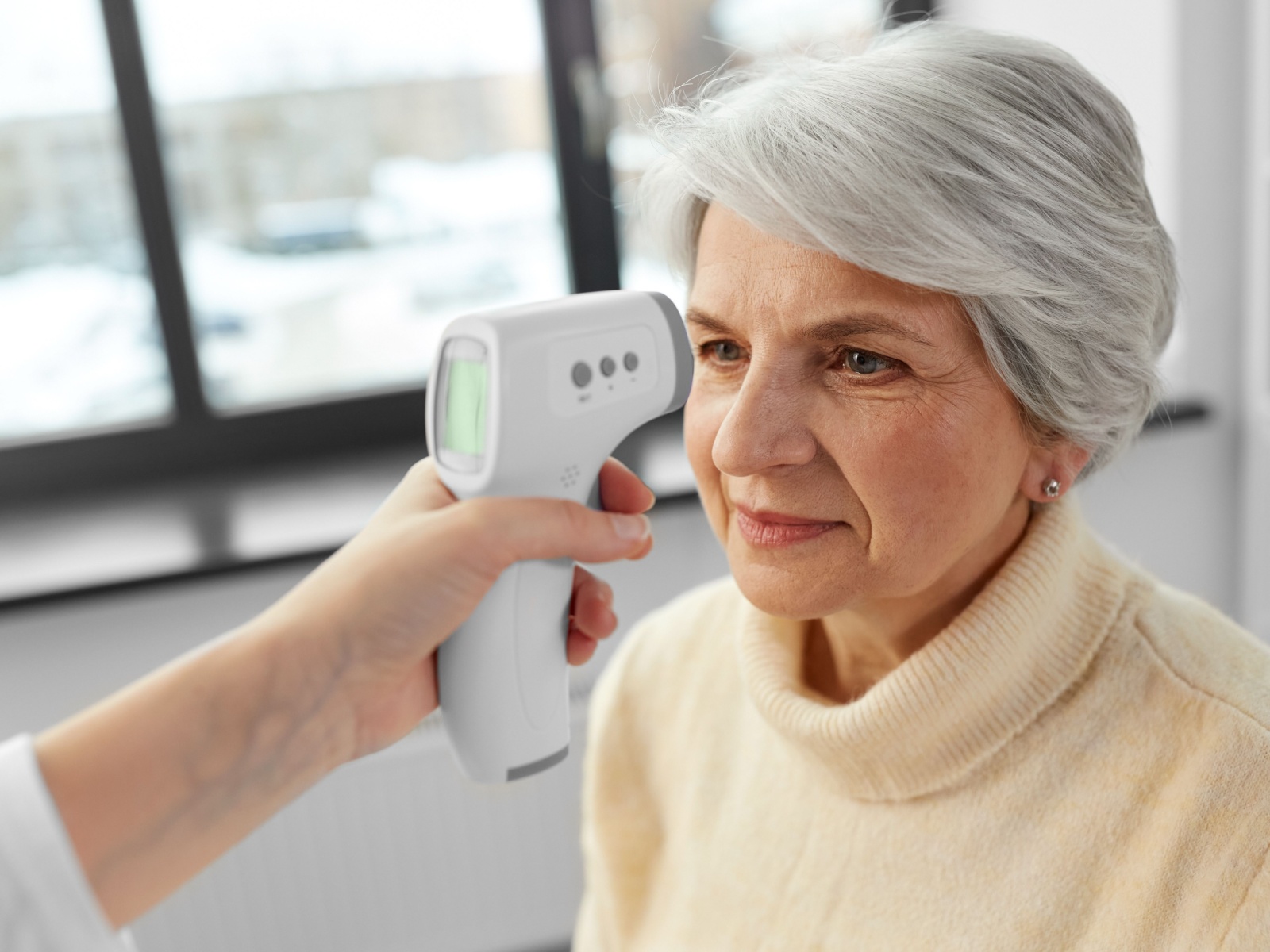 A woman having her temperature taken.